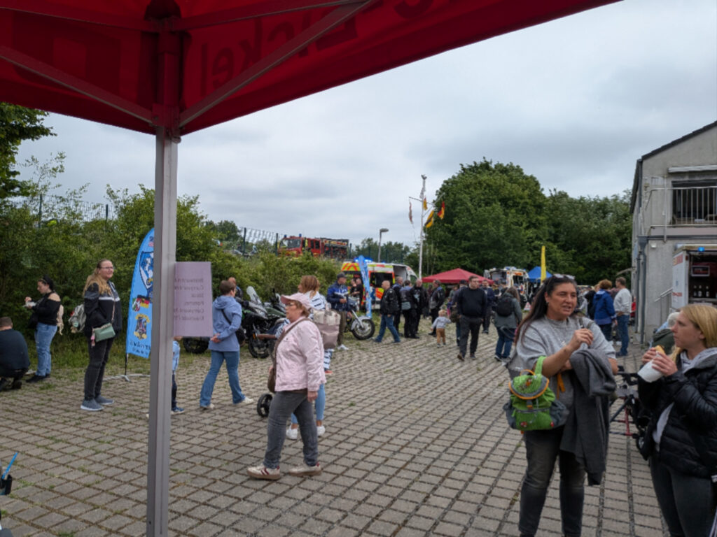 Blick aus dem Zelt auf das Festgelände mit Besuchern