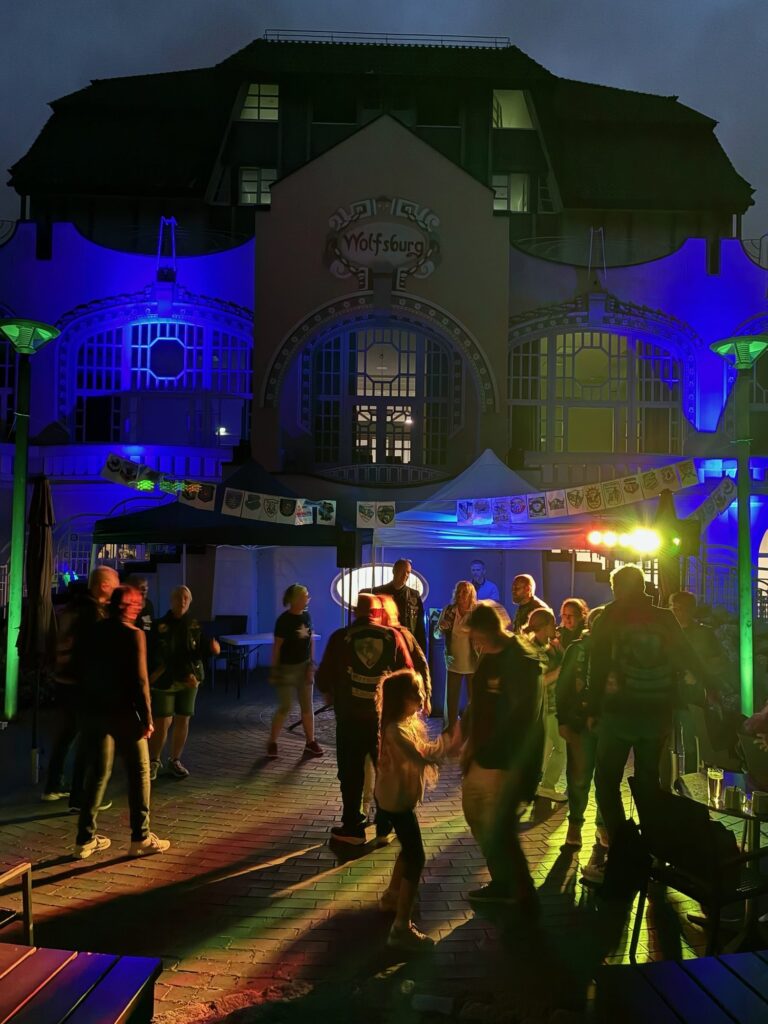 Tanzende Gäste im bunt beleuchteten Hof der Wolfsburg