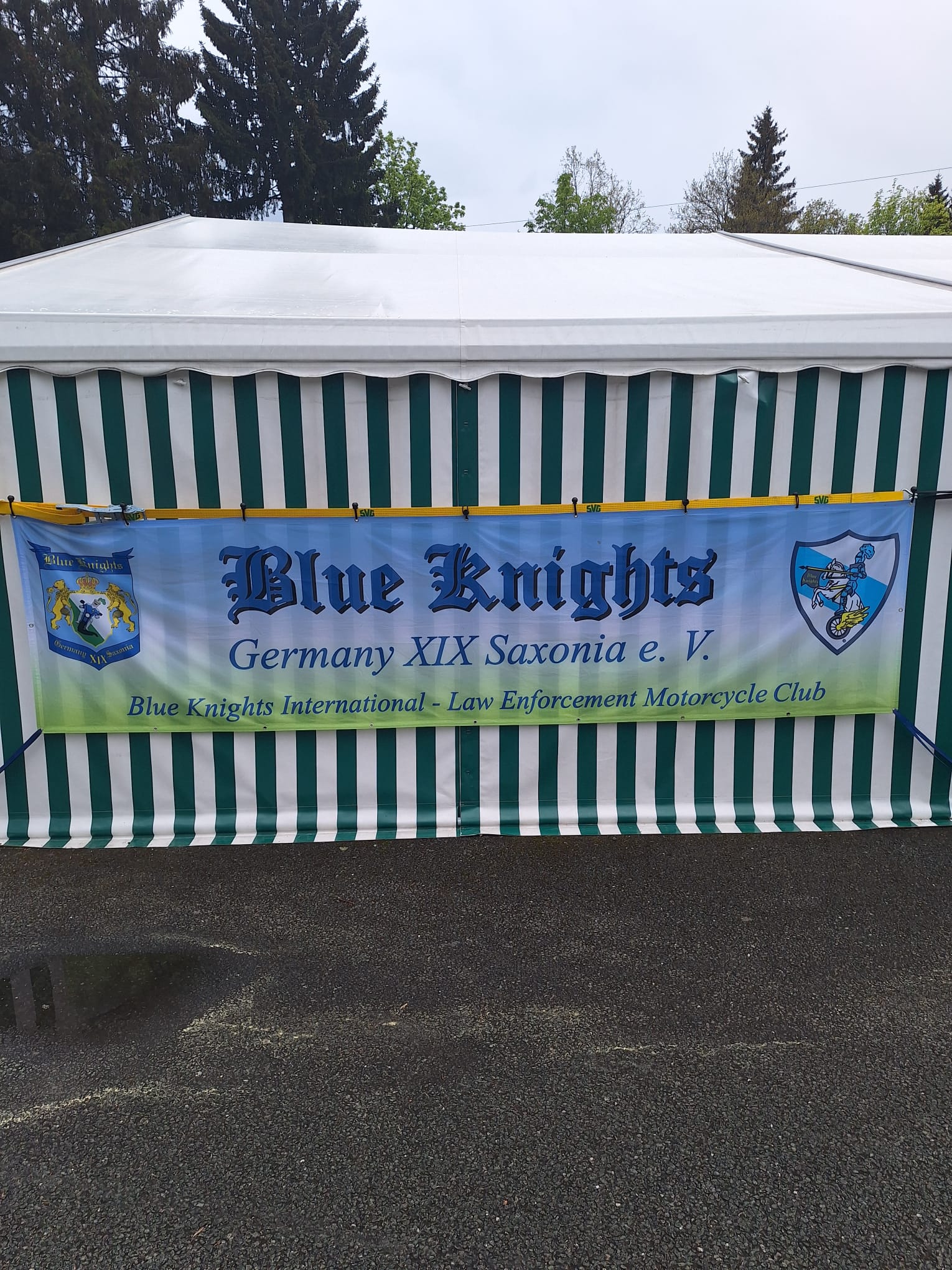 Grün-weiß gestreiftes Festzelt mit großem Banner „Blue Knights Germany XIX Saxonia e.V.“