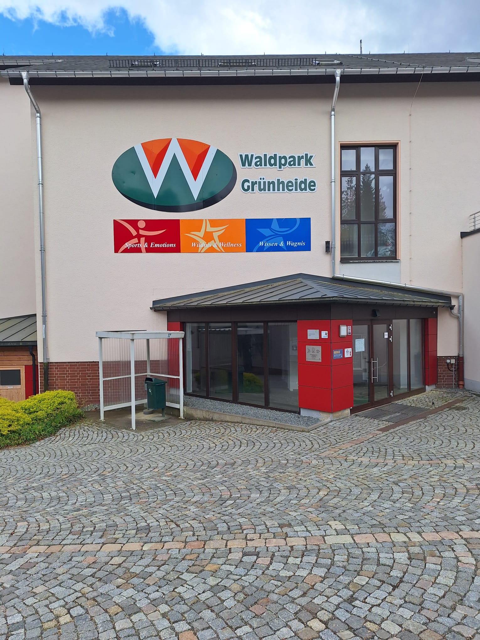 Eingang des Feriendorfs KiEZ Waldpark Grünheide mit Kopfsteinpflaster-Vorplatz