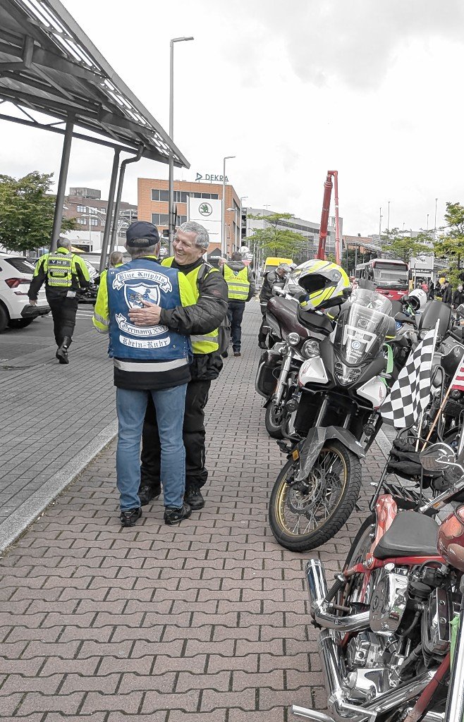Herzliche Begr&uuml;&szlig;ung zweier Mitglieder an den aufgereihten Motorr&auml;dern