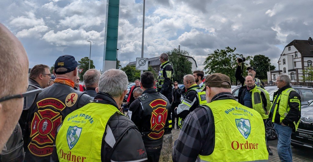 Fahrer-Briefing der Ordner vor dem Korso unter bew&ouml;lktem Himmel