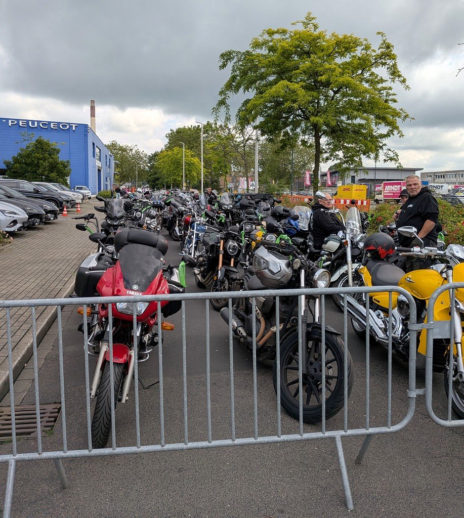 Lange Reihe startbereiter Motorr&auml;der hinter einem Absperrgitter in der Korso-Aufstellung